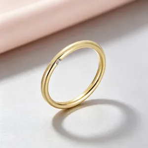 Gros plan sur la bague minimaliste en acier titane doré avec détail de zircon latéral.