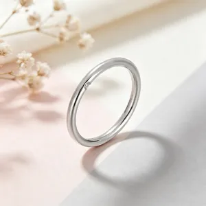 Gros plan détail bague fine minimaliste en acier titane avec un petit diamant sur le côté.