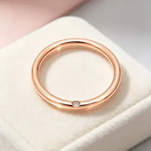Bague minimaliste en acier titane or rose avec diamant latéral discret pour un style chic.