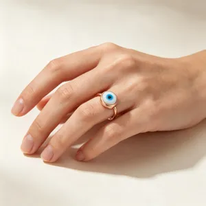 Close-up van een stijlvolle roségouden boze oog ring gedragen, met blauw emaille ontwerp.