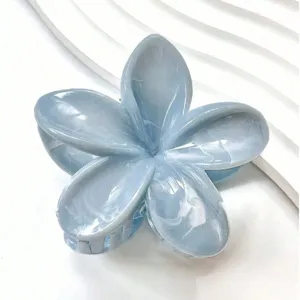 Vue détaillée de la texture marbrée élégante sur une pince à cheveux fleur bleu clair.