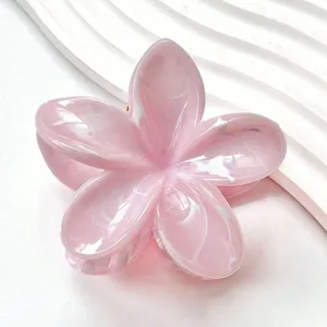 Détail de la pince à cheveux en forme de fleur de plumeria marbrée rose avec dégradé.