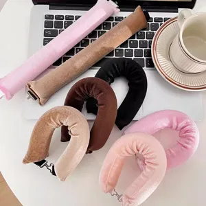 Multi-color velvet heatless hair curlers with clips displayed on a white laptop