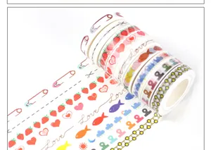 Close-up detail of colorful decorative washi tape rolls featuring cute strawberry heart patterns.