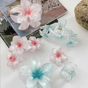 Summer gradient plumeria flower hair claws in translucent pink and blue resin style.