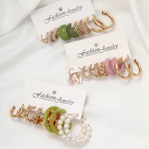 Detaillierte Makroansicht von Modeschmuck-Ohrring-Sets mit Gold-Creolen und Perlen
