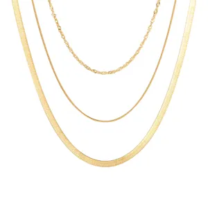 Detail view of gold layered necklace set featuring snake chain and rope chain designs