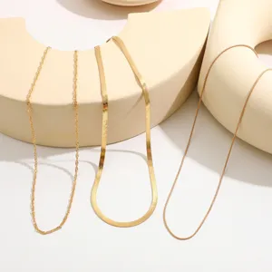 Detail view of three distinct golden necklaces with varied chain textures on geometric props