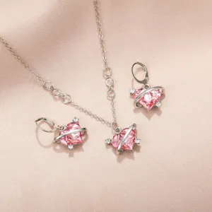 Gros plan d'un ensemble collier et boucles d'oreilles cœur planète rose Barbie