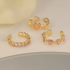 Detailed view of gold rings set featuring pink heart stones and simulated cat eye heart gem