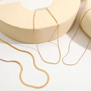 Close-up detail of gold snake and water wave necklaces with geometric display props.