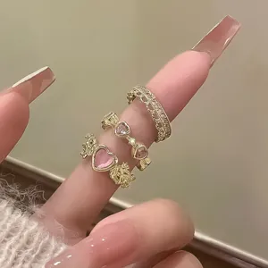Set of three vintage-style gold rings with pink heart cat's eye stones and thorn details