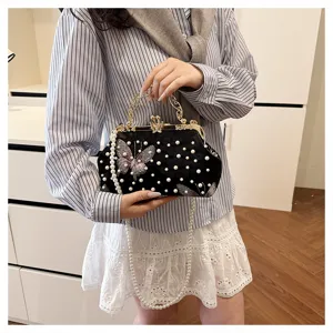 Elegante bolso de mano de terciopelo negro con perlas y detalle de mariposa