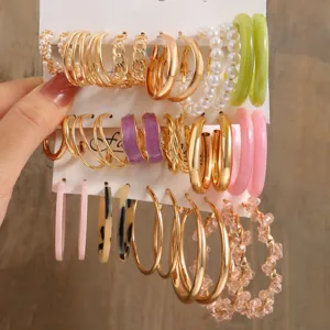 Großes Set mit goldenen Creolen und bunten Acrylohrringen auf einer Displaykarte präsentiert