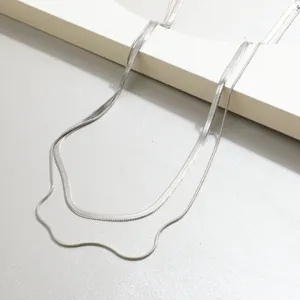 Detailed view of silver double-layer stacking herringbone and snake chain necklace