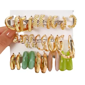 Set aus goldfarbenen Creolen und Perlen-Resin-Ohrringen auf weißer Displaykarte