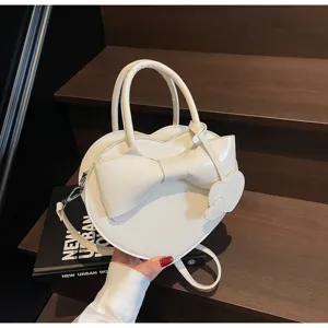 Elegante bolso de mano blanco en forma de corazón con lazo grande y correa ajustable