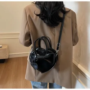 Vista trasera de una modelo con un bolso de mano negro con forma de corazón y lazo