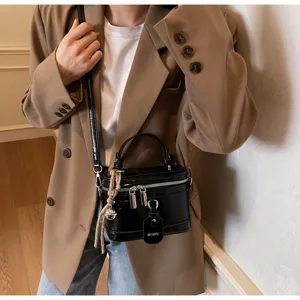 Close-up of a stylish black box bag with silver zippers and MEIGEFEI tag