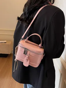 Trendy pink leather box-style handbag for women featuring a top handle and shoulder strap