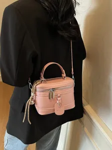 Stylish pink leather box bag with crossbody strap and top handle, casual model look