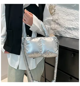 Detailopname van een zilveren gewatteerde handtas van nylon in een moderne omgeving