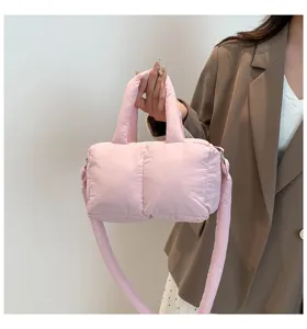 Detailopname van een roze gewatteerde puffy handtas van nylon met handvat
