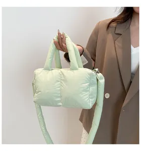 Detail van lichtgroene gewatteerde nylon tas met schouderband