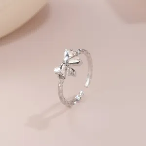 Nahaufnahme eines silbernen Schleifenrings mit funkelnden facettierten Steinen.