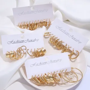 Vista detallada de sets de pendientes de aro dorados con perlas y diseños trenzados en tarjetas.