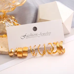 Close-up of assorted gold-tone C-shape and twisted hoop earrings on display card