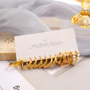 Detailed view of gold-tone twisted and faux pearl earring set on display card.