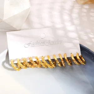 Detailed view of elegant gold-tone metal twist and smooth C-shaped hoop earring set on card