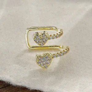 Primo piano dettagliato di un earcuff doppio dorato con cuori in strass
