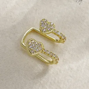 Primo piano macro di un ear cuff dorato a doppio strato con cuori ricoperti di pietre.