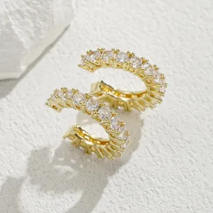 Dettaglio di un ear cuff placcato oro con una fila di scintillanti zirconi bianchi