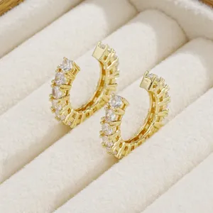 Primo piano di ear cuff placcati in oro con una fila di scintillanti pietre di zircone