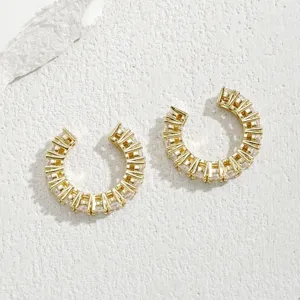 Dettaglio macro di polsini per orecchie placcati in oro con zirconi cubici lucidi