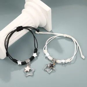 Primo piano dettagliato di braccialetti di coppia intrecciati con ciondoli a stella