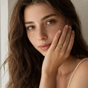 Close-up of a gold-plated stainless steel ring with three fish design on a model finger