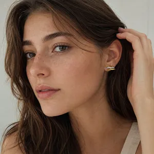 Close-up view of elegant three-fish stud earrings in gold and silver finish on a model