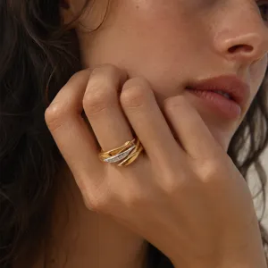 Close-up of elegant two-tone fish shaped ring with pavé stones on model finger.