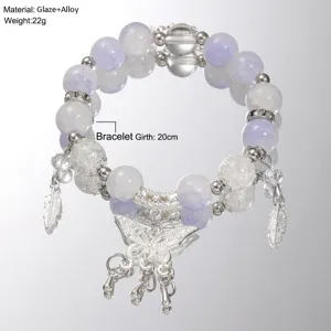 Detailed view of handmade glazed beaded bracelet with butterfly and feather charms