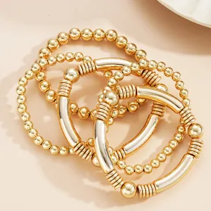Minimalistische set van 5 gouden kralenarmbanden met gebogen buisdetails voor layering stijl