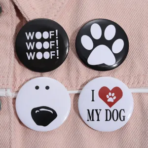 Macro view of dog-themed tinplate brooches with Woof and I Love My Dog designs.