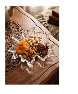 Vista detallada de plato de vidrio con forma de hoja de arce con frutas secas y nueces