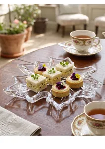 Detalle de una bandeja de cristal con forma de hoja de arce y bocadillos elegantes