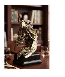 Vista detallada de la escultura de águila de resina dorada en un escritorio clásico