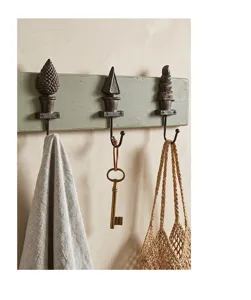 Vue détaillée de crochets muraux décoratifs en fonte rustique sur planche en bois