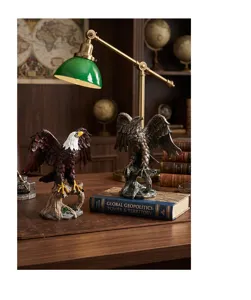 Detailansicht von Vintage-Adlerstatuen aus Harz auf einem Schreibtisch mit Lampe